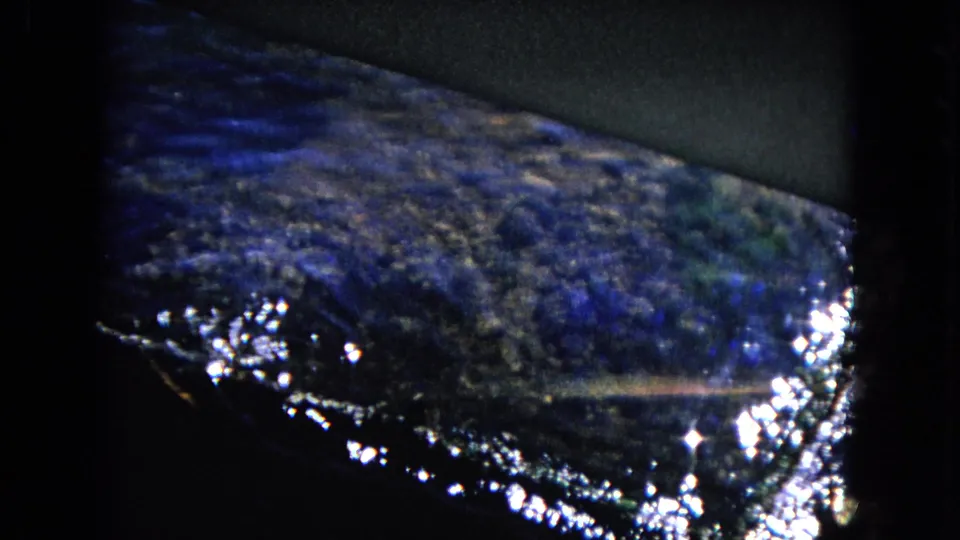 Blue-toned 1968 Honolulu 8mm view of water, shoreline or harbor edge, and bright reflected highlights.
