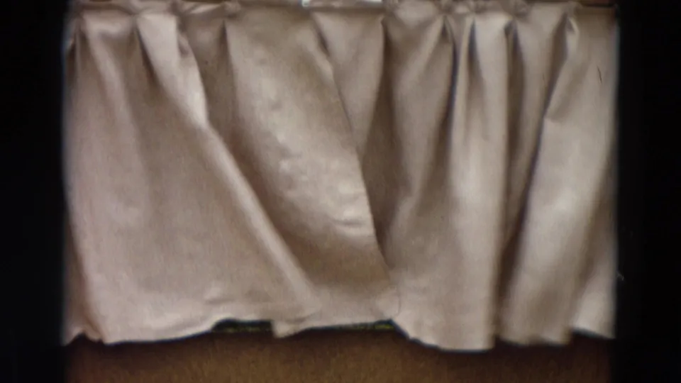 1968 8mm Lahaina Maui home-movie frame showing a closed light curtain on a small puppet-stage setting.