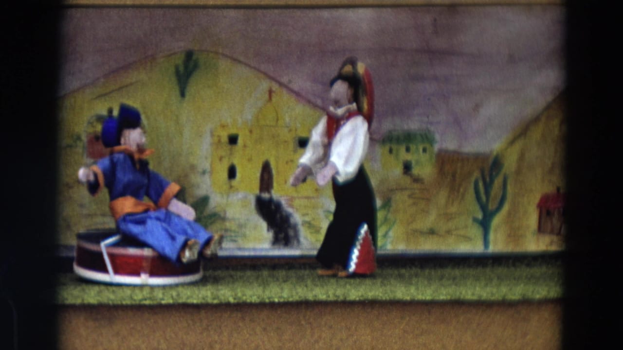 1968 Lahaina Maui 8mm frame showing a seated blue puppet and a standing costumed puppet performing on a small stage.