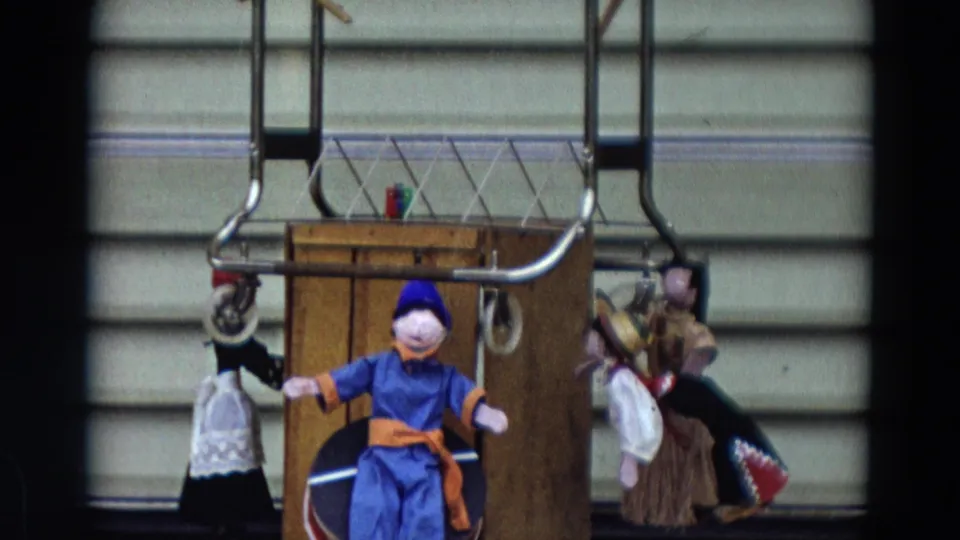 The puppet arrangement continues in the 1968 Lahaina, Maui home movie, with a blue figure centered before a wooden stage and side puppets.