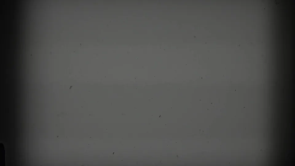 Underexposed opening frame from a 1968 Minnesota 8mm home movie, showing mostly dark film area with visible grain and edge falloff.