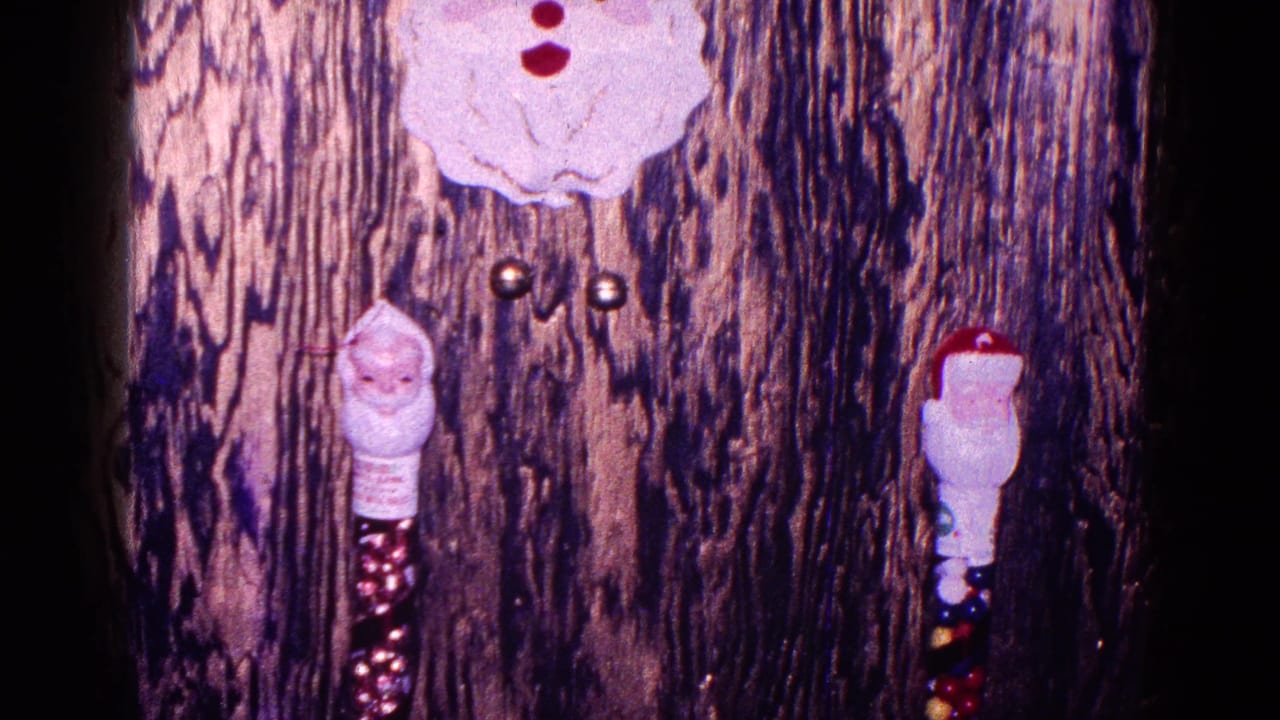 1968 Minnesota home-movie frame showing wood paneling with Santa decorations above a Christmas mantle display.
