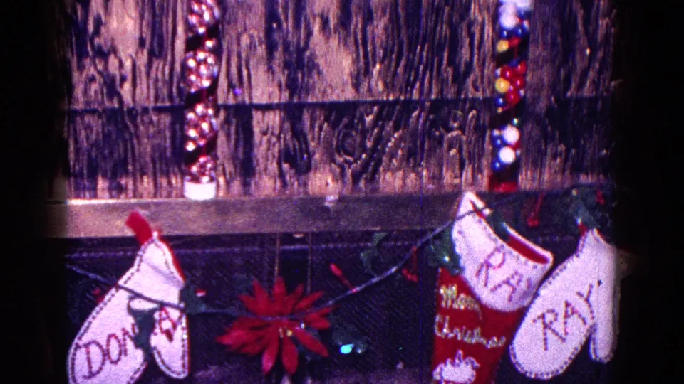 1968 Minnesota Christmas mantle with stockings labeled Donna and Ray, string lights, poinsettia, and Santa decorations.