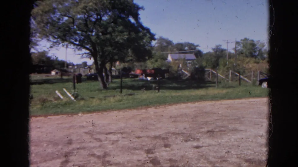 Final 1968 Wauconda, Illinois frame showing a fenced yard, large trees, a house, gate area, and dirt road foreground.