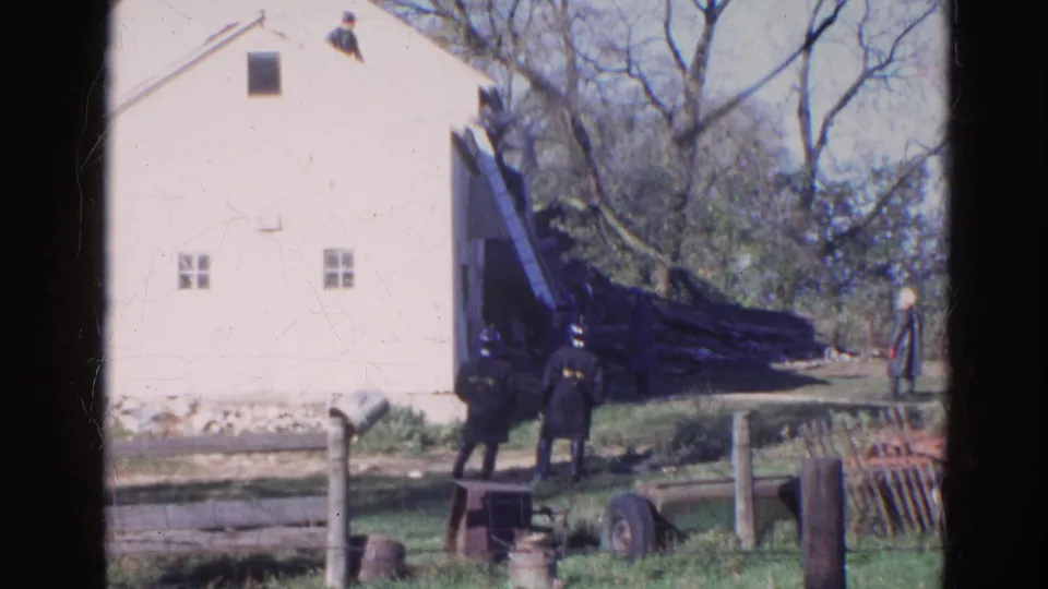 1968 Wauconda, Illinois 8mm still showing uniformed adults below a roof ladder at a white house exterior.
