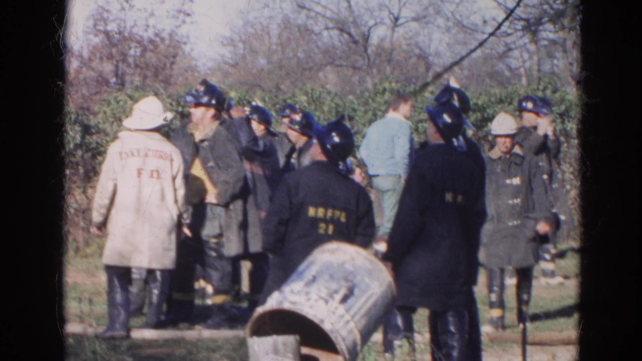 Uniformed emergency personnel gather outdoors near an overturned barrel.
