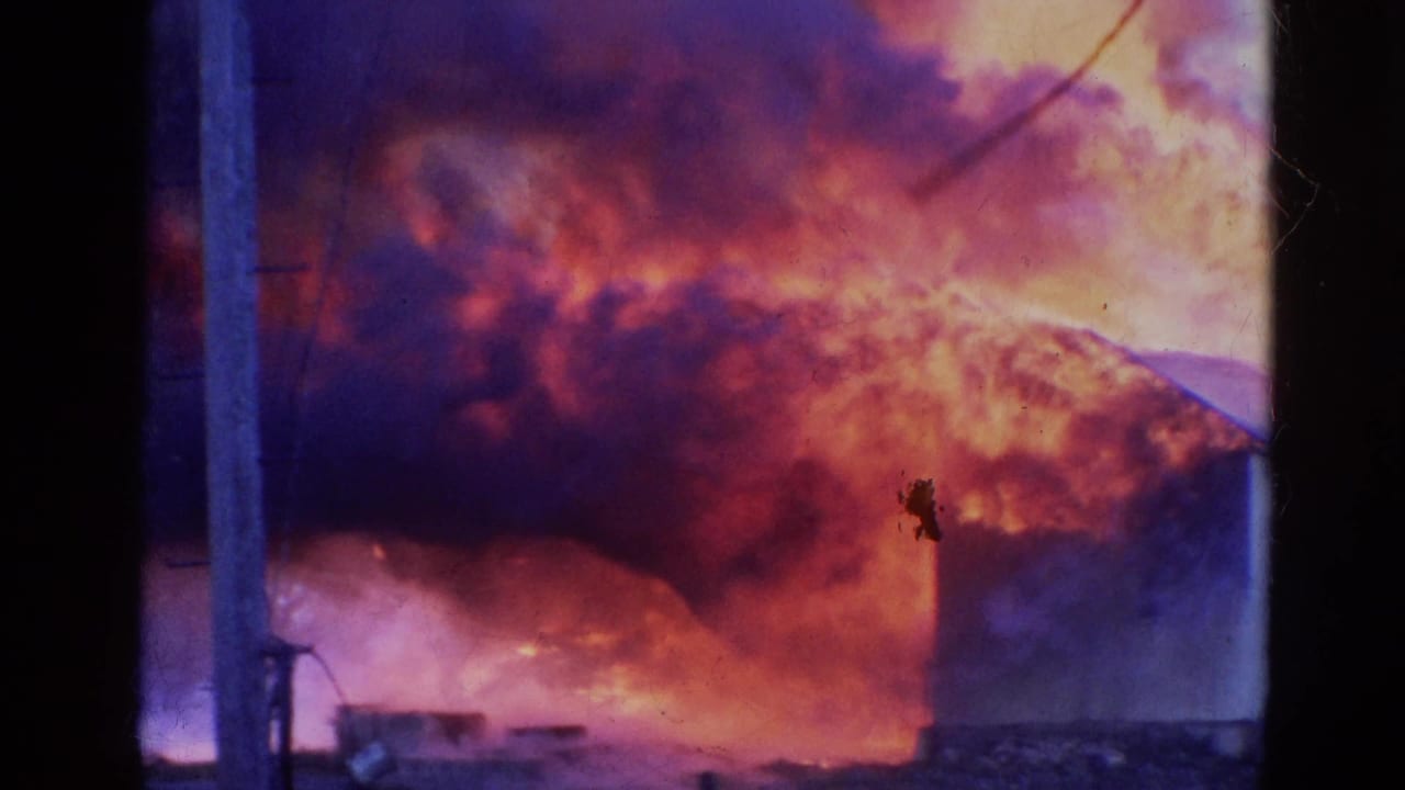 1968 Wauconda, Illinois 8mm frame showing a large fire burning behind trees, smoke, and a utility pole.