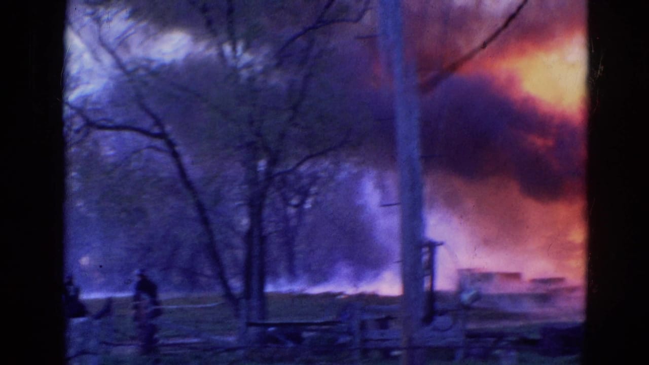 1968 Wauconda, Illinois frame showing smoke and flames through trees as firefighting water reaches the fire area.