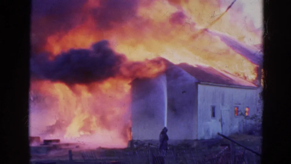 Late-1960s 8mm footage from Wauconda shows a firefighter near a barn while fire and smoke dominate the background.