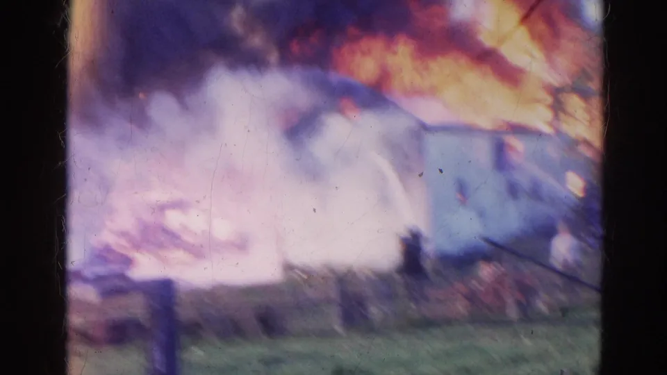 Flames and smoke dominate the frame as the Wauconda building fire continues behind foreground film borders.