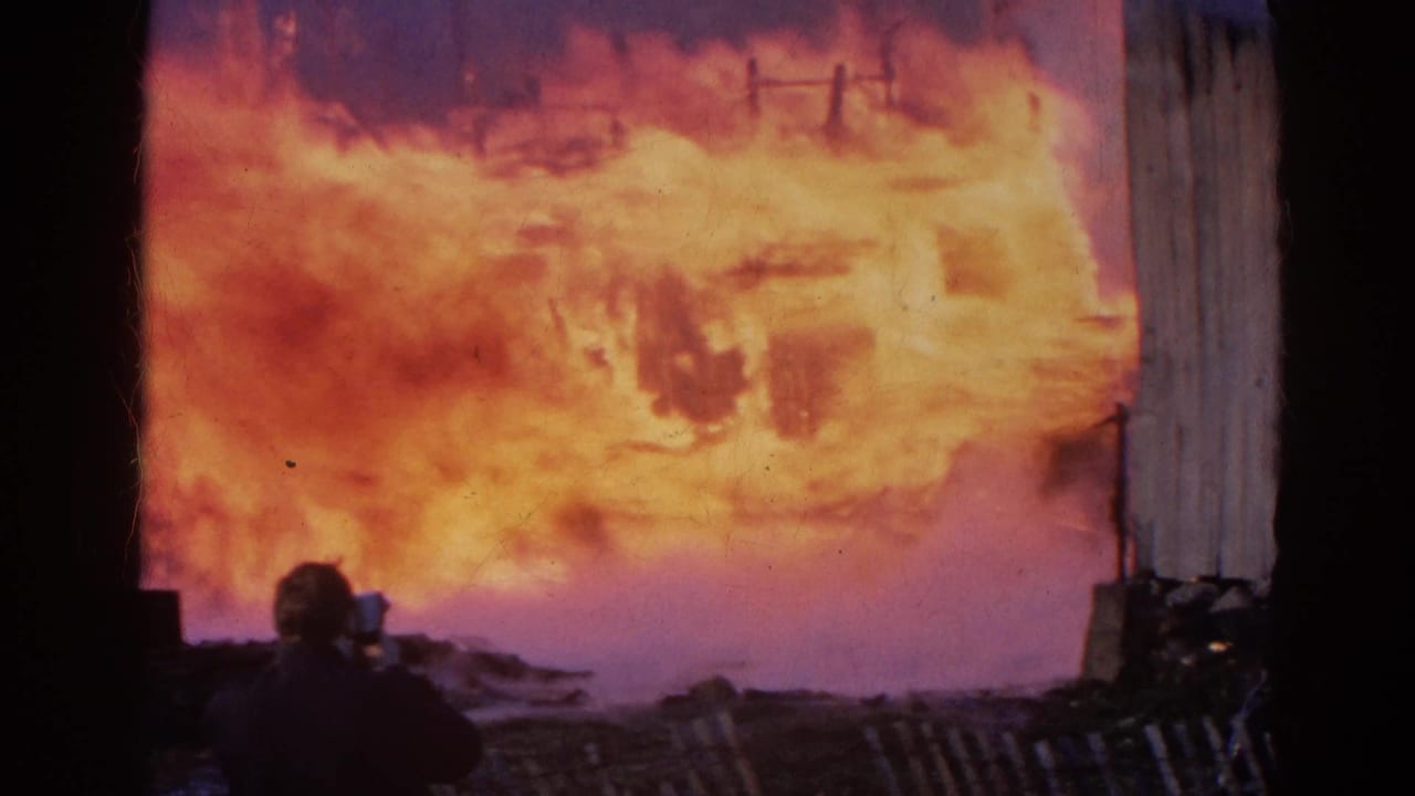 1968 Wauconda, Illinois fire scene with a foreground silhouette possibly filming or watching as flames engulf the background.