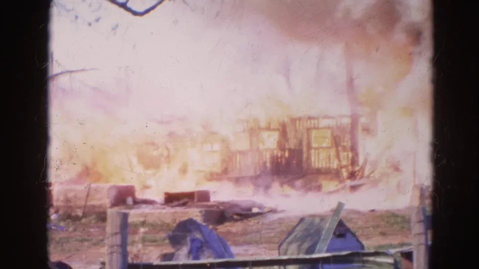 Wauconda, Illinois fire footage shows a skeletal structure burning through pale smoke, with debris and fencing in the foreground.