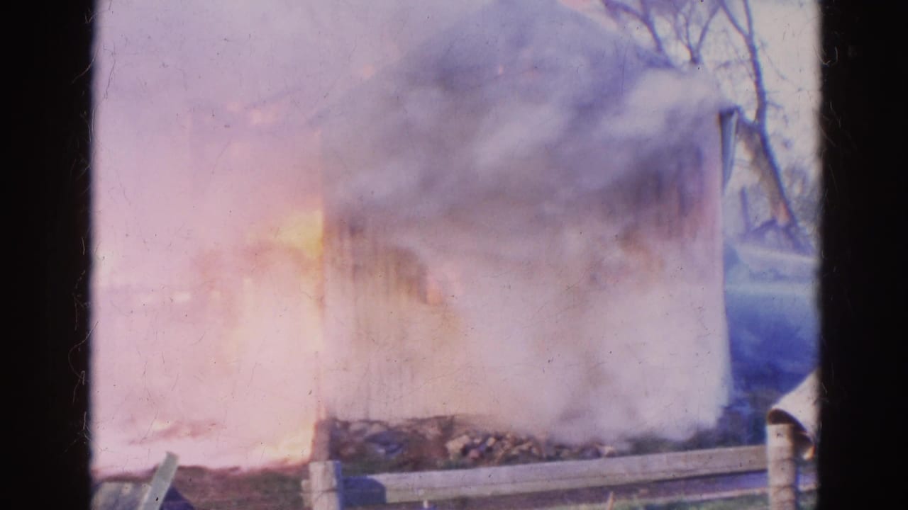 1968 Wauconda, Illinois 8mm footage shows smoke and fire engulfing a rural wooden structure behind a fence.