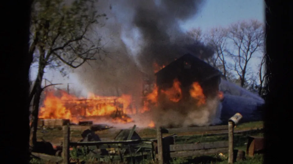 1968 Wauconda, Illinois 8mm frame showing intensified flames around a rural building with thick smoke overhead.