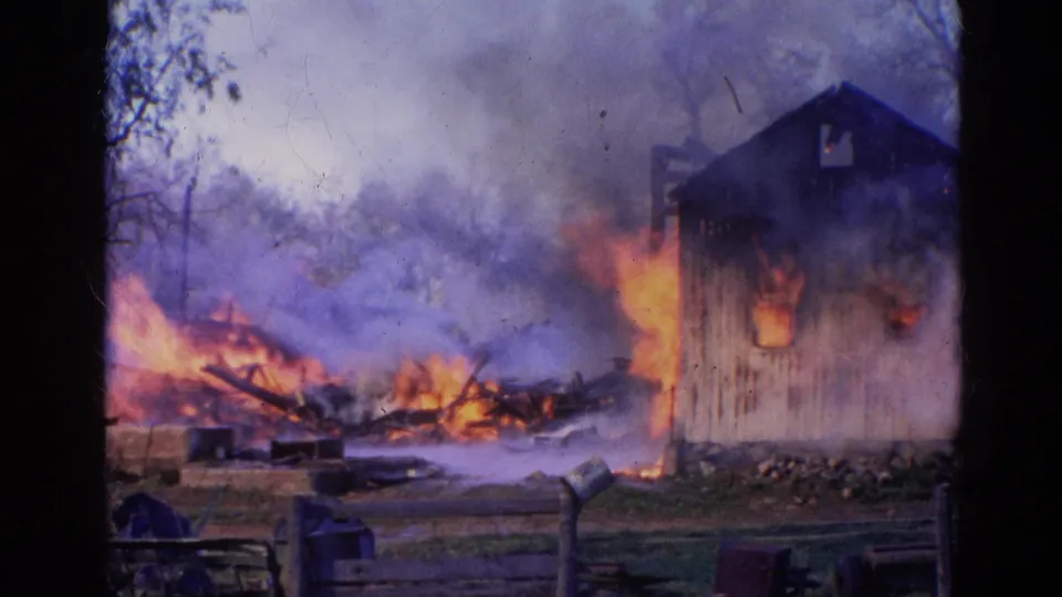 The final frame shows the barn and surrounding debris still burning, with dense smoke drifting through bare trees in rural Wauconda, Illinois.