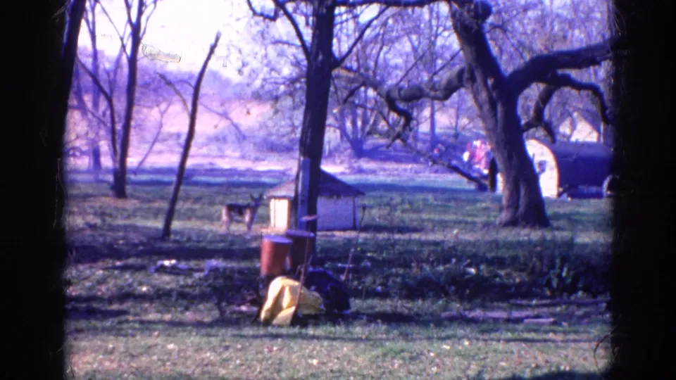 A later Wauconda fire frame shows smoke beyond trees, a parked vehicle, a small shed-like structure, grass, and scattered objects in the foreground.