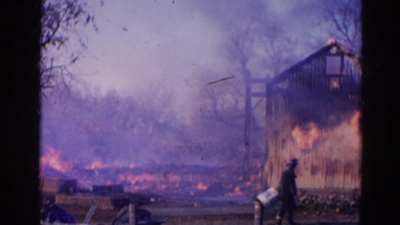 Wooden structure burning with smoke, flames, bare trees, and a firefighter figure nearby.