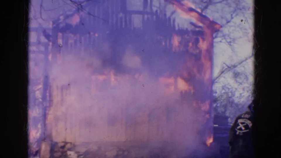 1968 Wauconda, Illinois 8mm frame showing dense smoke and flames consuming the side of a wooden building.