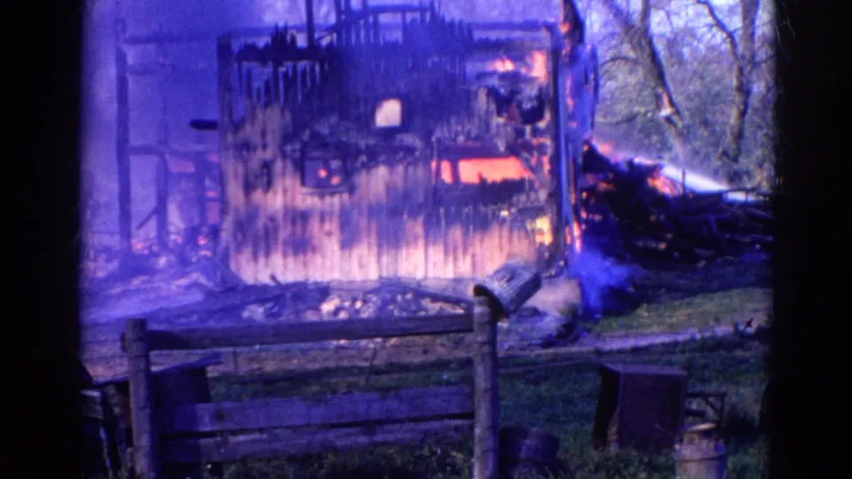 1968 Wauconda frame showing flames in a wooden building as water spray reaches the fire from the right.