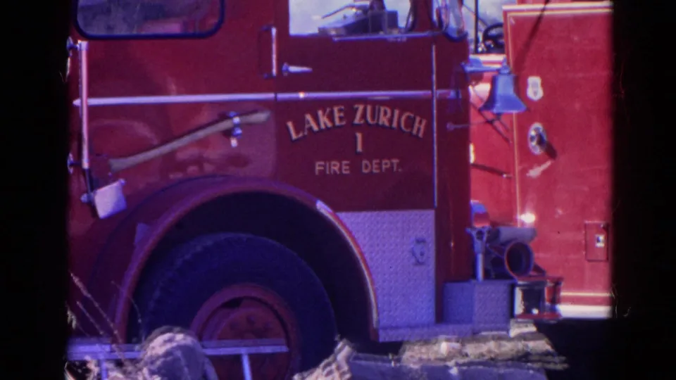 Close 8mm frame of a red Lake Zurich Fire Dept. truck marked with department lettering and the number 1.