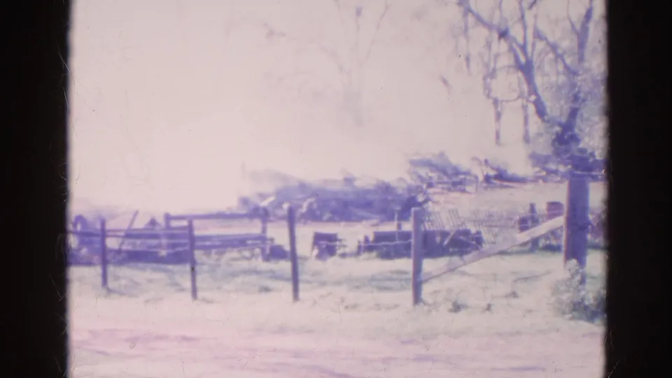 Rural Wauconda frame with smoke lingering over a fenced yard, bare trees, and soft faded 8mm color.