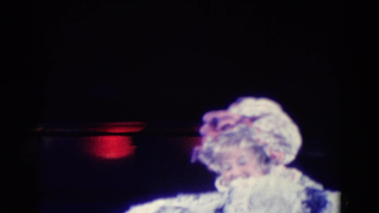 1969 Chicago 8mm frame showing a pale spotted chicken puppet under low stage lighting, with the scene soft and partially obscured.