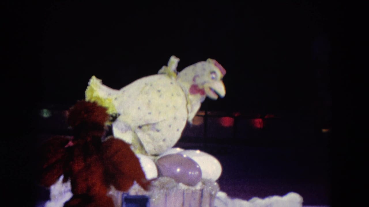 1969 Chicago stage frame with a spotted chicken puppet perched above oversized eggs while a costumed performer stands close by.