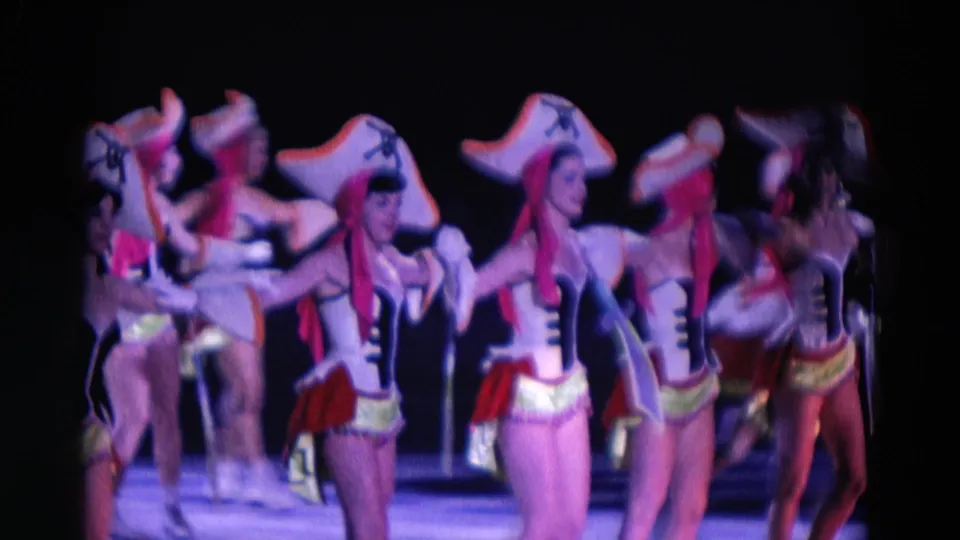Costumed women in pirate-style hats and corset-front outfits skate in formation during the 1969 Chicago ice show.