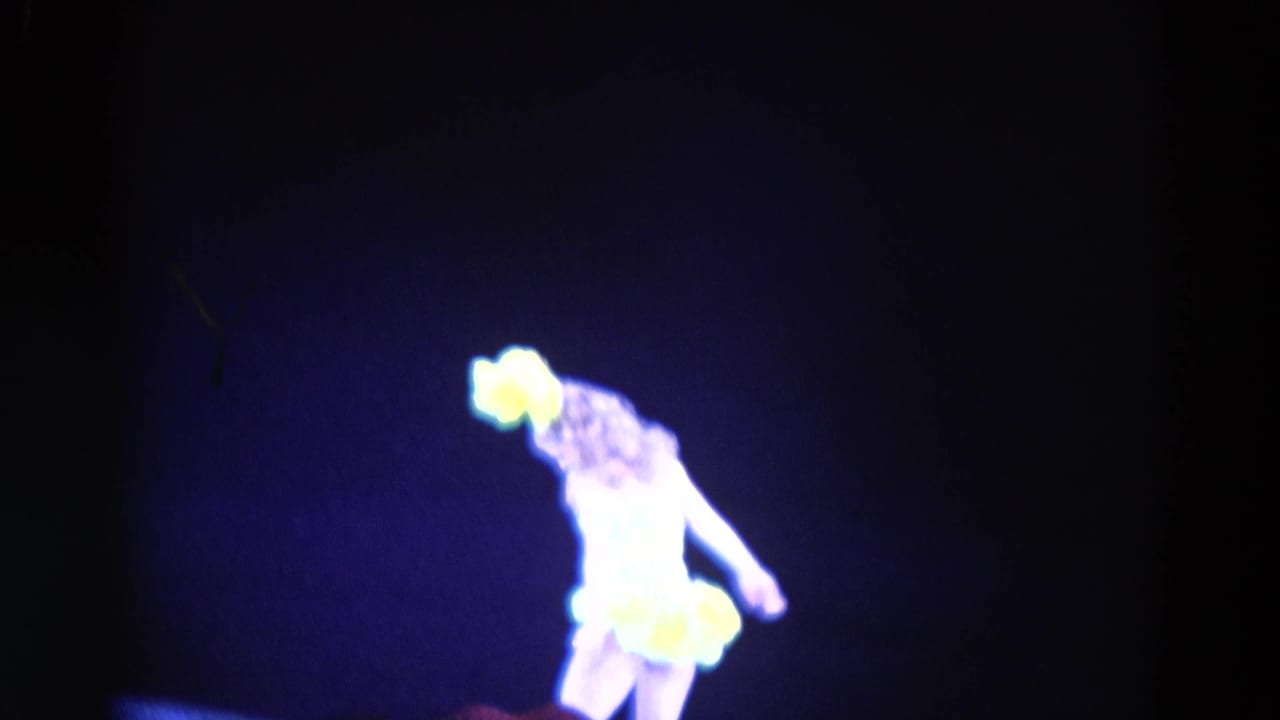 The 1969 Chicago stage performer leans sideways, her yellow costume glowing under blue theatrical light.