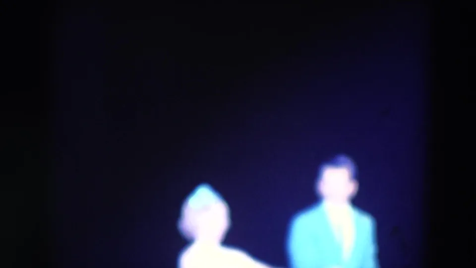 The woman and man share the stage in the 1969 Chicago dance clip, softly focused under purple light.