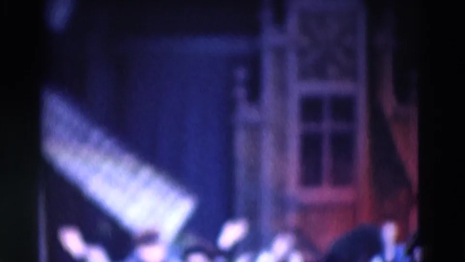 Soft 8mm frame from the 1969 Chicago clip showing the couple performing before a house-like stage set with colored lighting.
