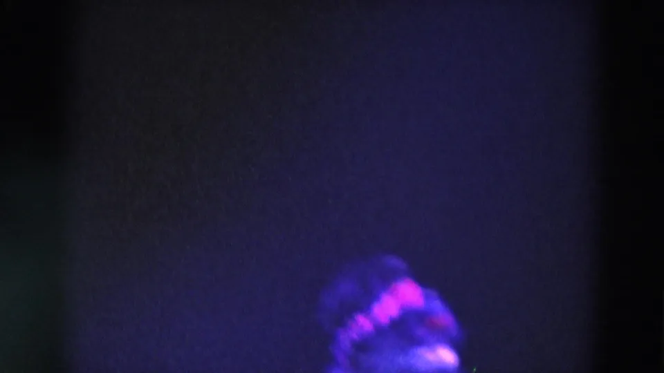 Late-1960s 8mm frame from Chicago with the skater partly obscured near the bottom edge amid dark purple-blue exposure.