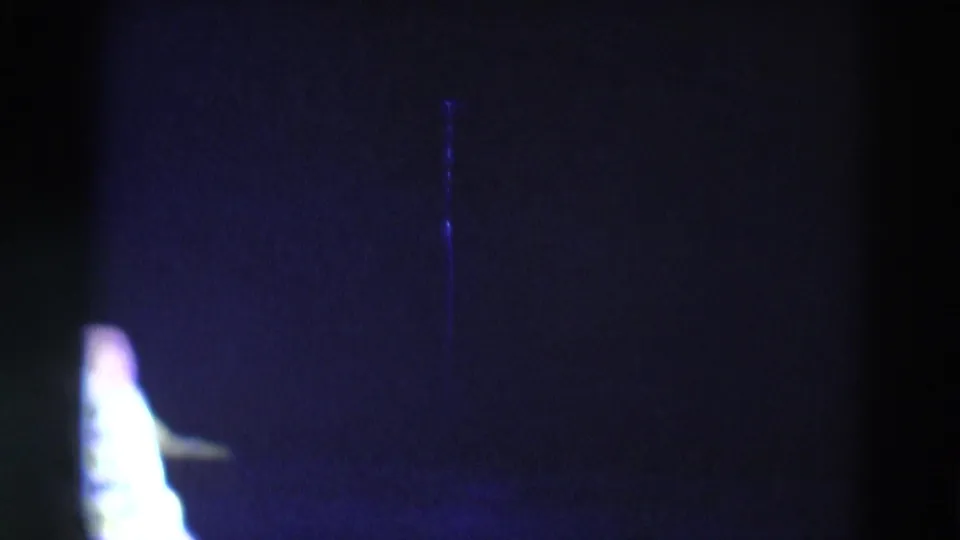 1969 Chicago 8mm frame with the skater partly visible near the bottom of a mostly dark, blue-purple lit scene.
