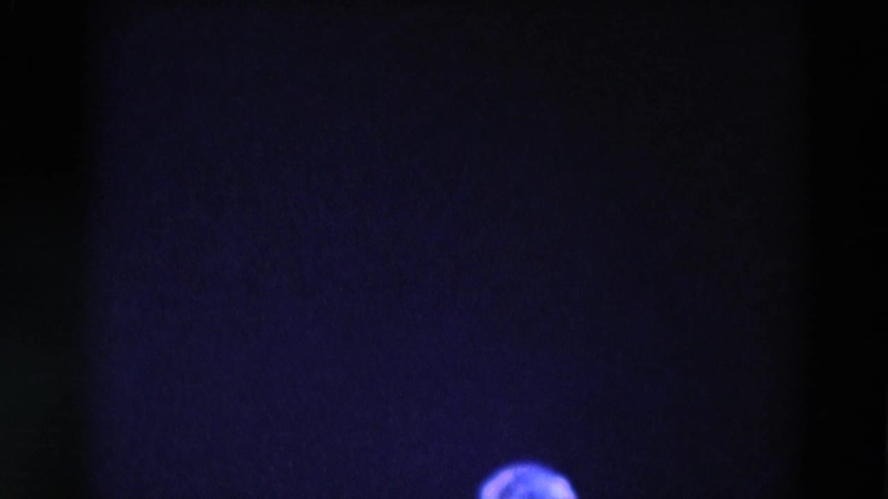 Mostly dark stage with a partial head near the lower edge.