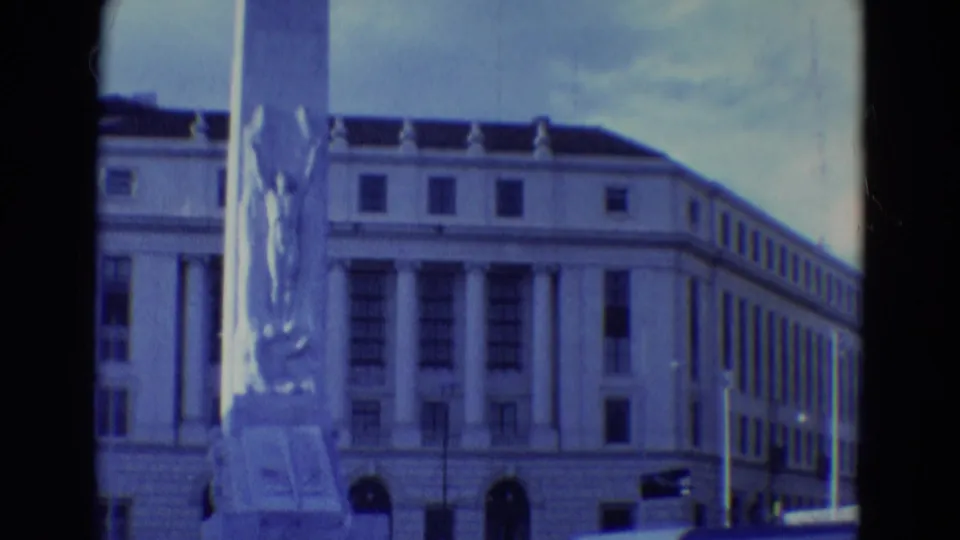1969 Diller, Nebraska frame showing the monument pedestal and sculpture against a formal civic-style building facade.