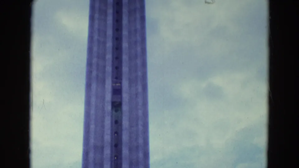 A tall elevated lift structure fills the frame against a cloudy sky in the supplied Diller, Nebraska home-movie clip.