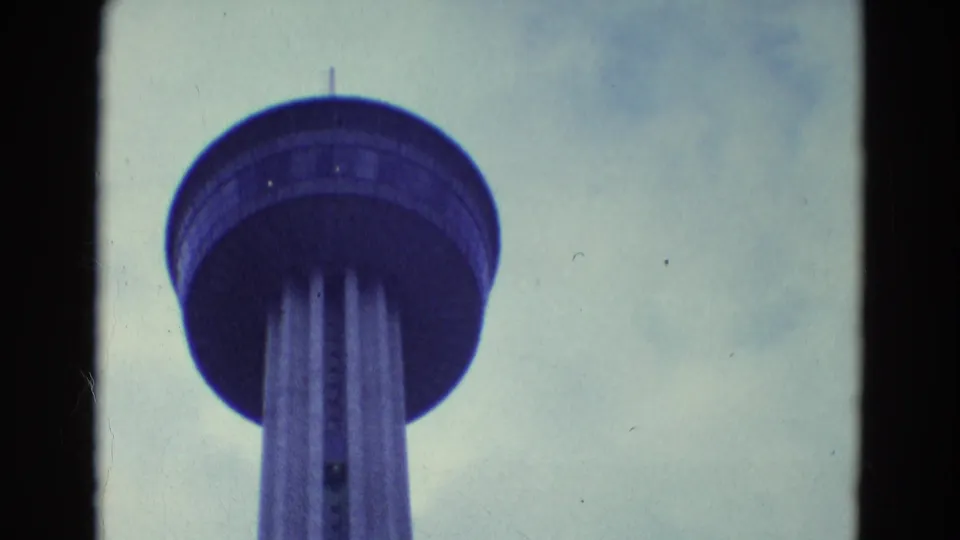 Low-angle 1969 Diller, Nebraska frame showing the observation tower deck and support columns in faded blue-gray 8mm color.