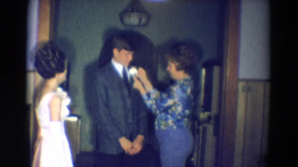 Diller, Nebraska 1969 frame showing the final moments of a lapel flower being fastened before a likely prom or formal dance.