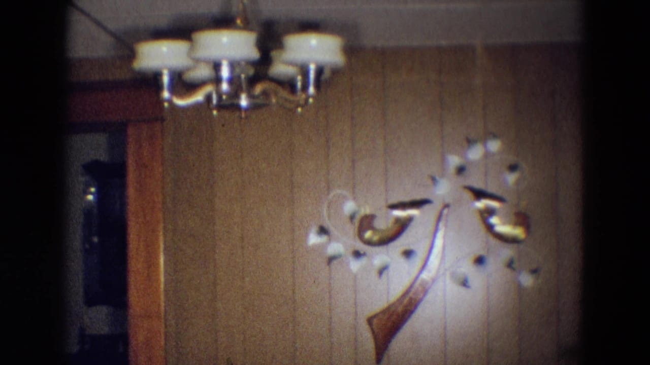 Wood-paneled wall with white-and-brass ceiling light and abstract wall sculpture.