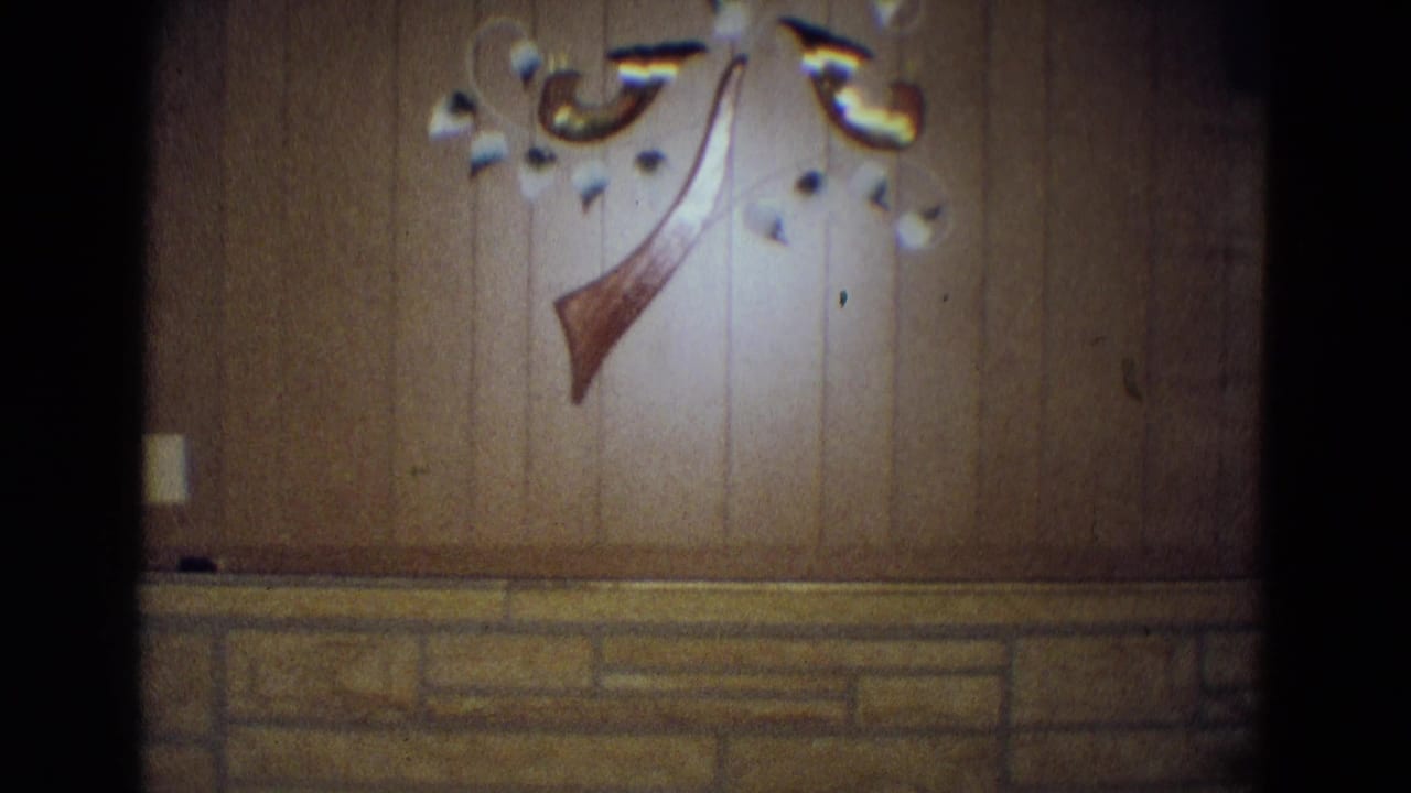 Wood-paneled wall with stone wainscot and decorative wall hanging.