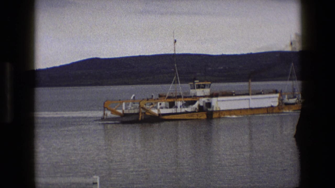 Ferry closer in harbor water with dark frame edges.