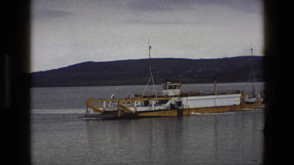 1969 England 8mm frame with the ferry continuing through the harbor, bordered by dark 8mm frame marks.