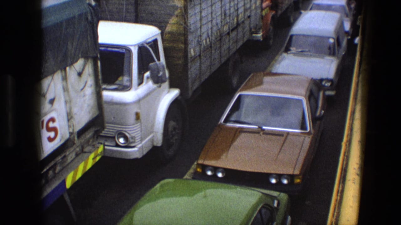 High-angle view of a white lorry and cars stopped tightly in one lane.