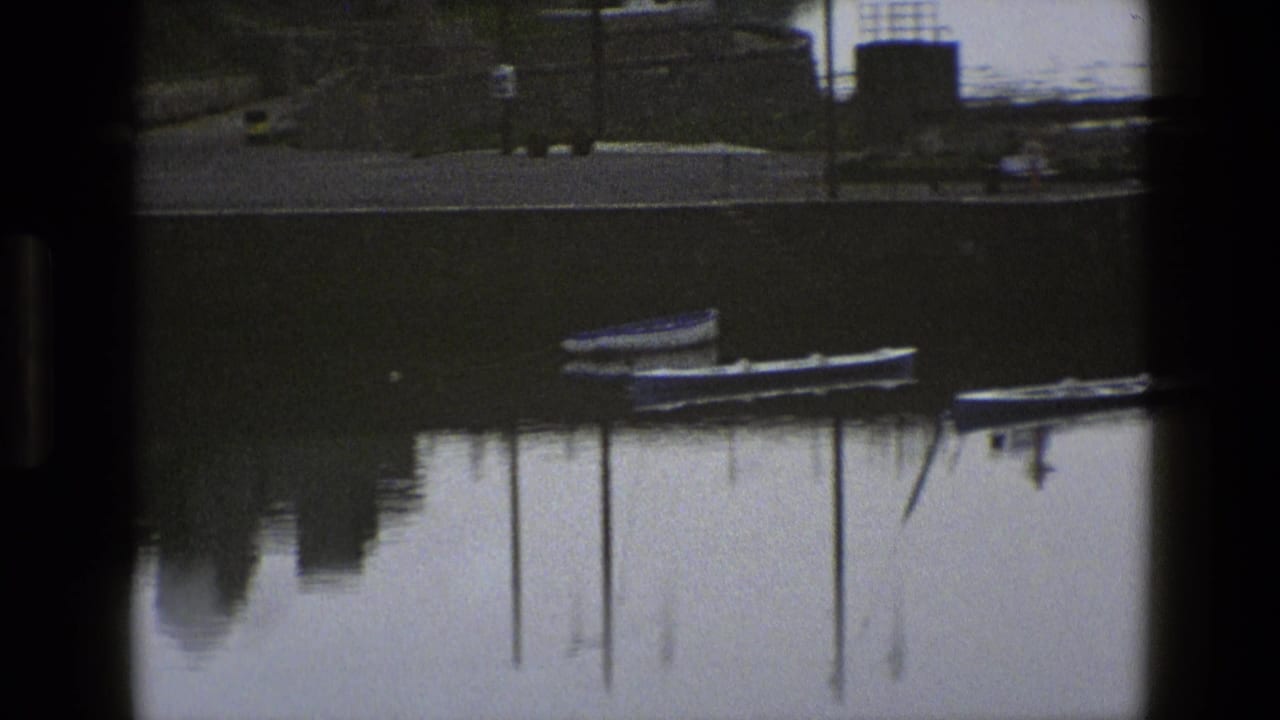 Moored boats and reflected posts in calm water with dark framing.
