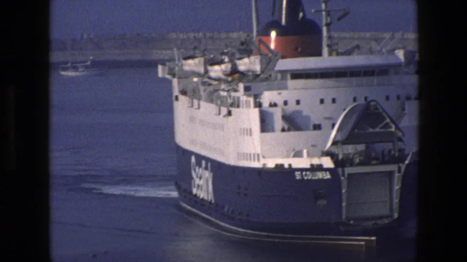 Closer 1969 England frame of the SeaLink ferry St Columbia, showing the open stern ramp, blue hull, and upper deck details.