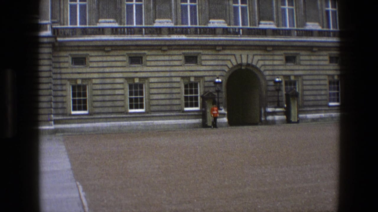 Stone palace facade with arched entrance and a guard in red uniform nearby.