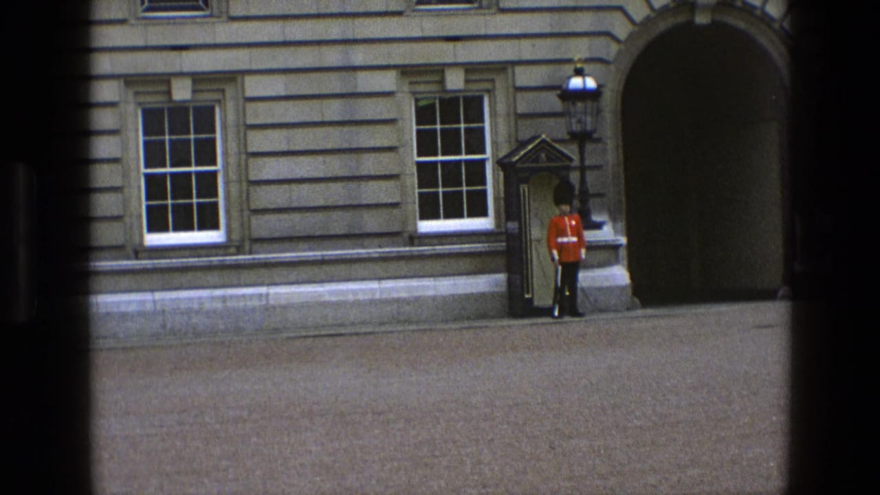 Visitor-shot 1969 England frame with a red-uniformed guard standing near a sentry box, sash windows, and an arched entrance.