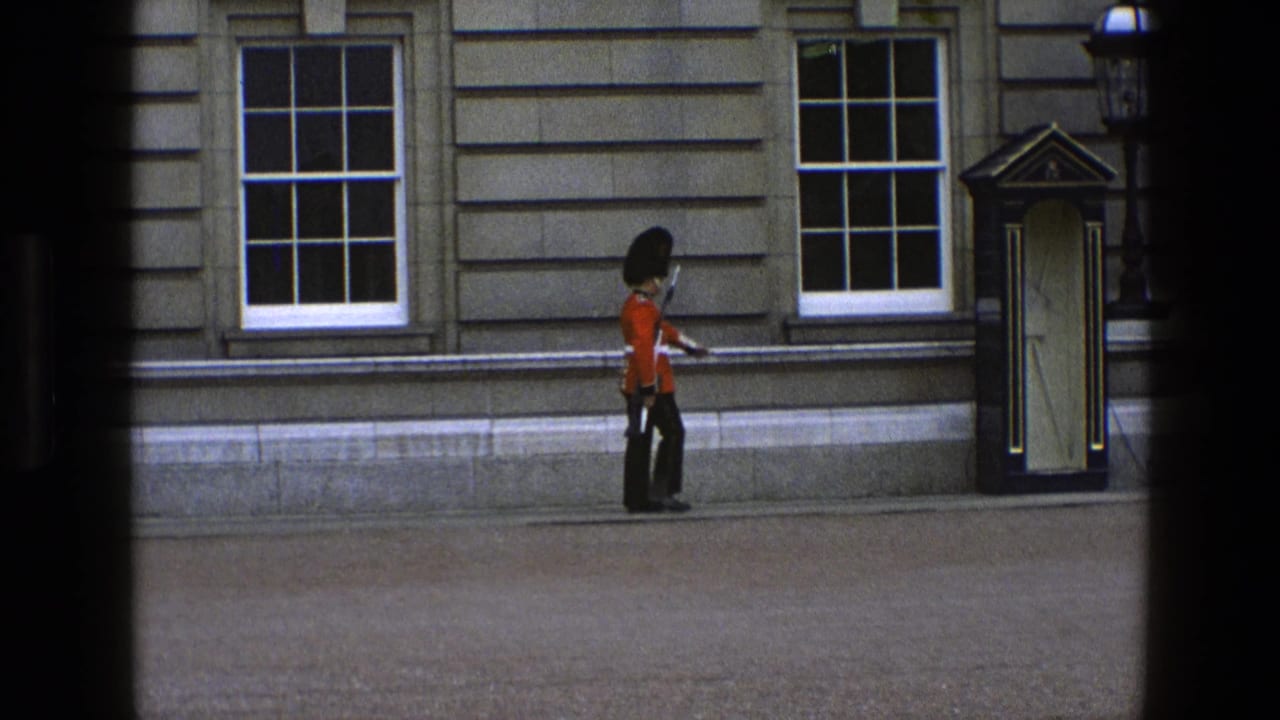 Guard carrying a rifle approaches a sentry box beside a stone building.