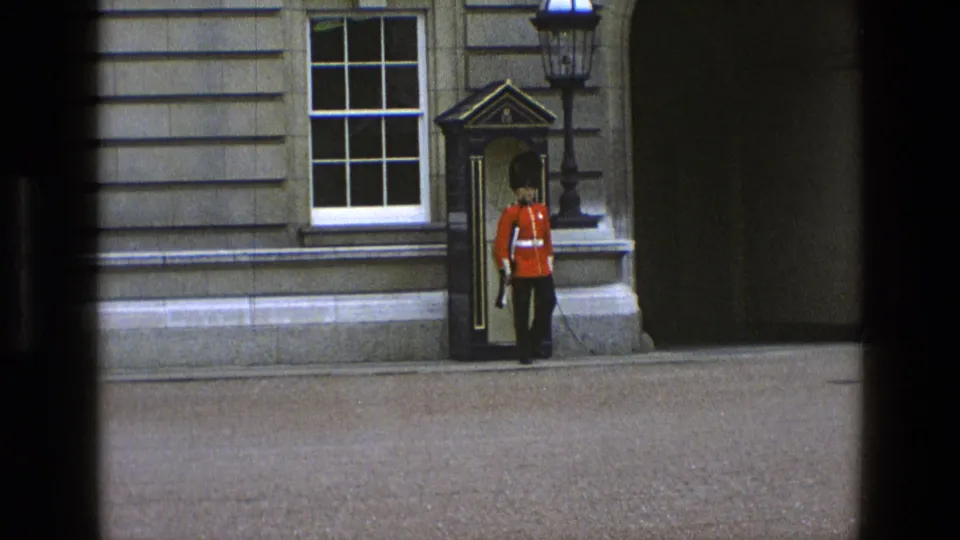 1969 England frame with a royal guard at attention in a sentry box setting outside a stone building.