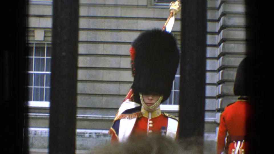 1969 England frame with a royal guard facing forward through bars and another guard turned away nearby.